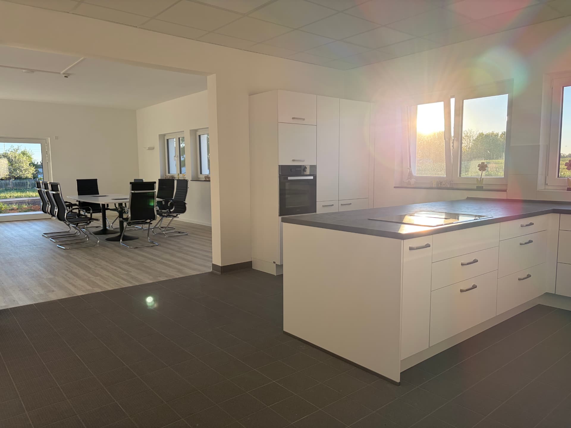 Offene Küche und Essbereich in Haus Yvonne mit hellen Möbeln und großen Fenstern