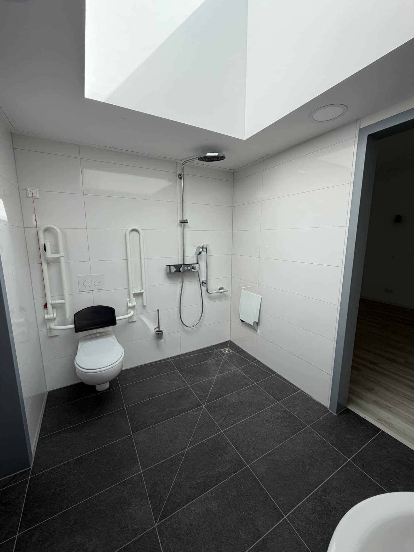 Barrierefreies Bad mit bodengleicher Dusche und Haltegriffen