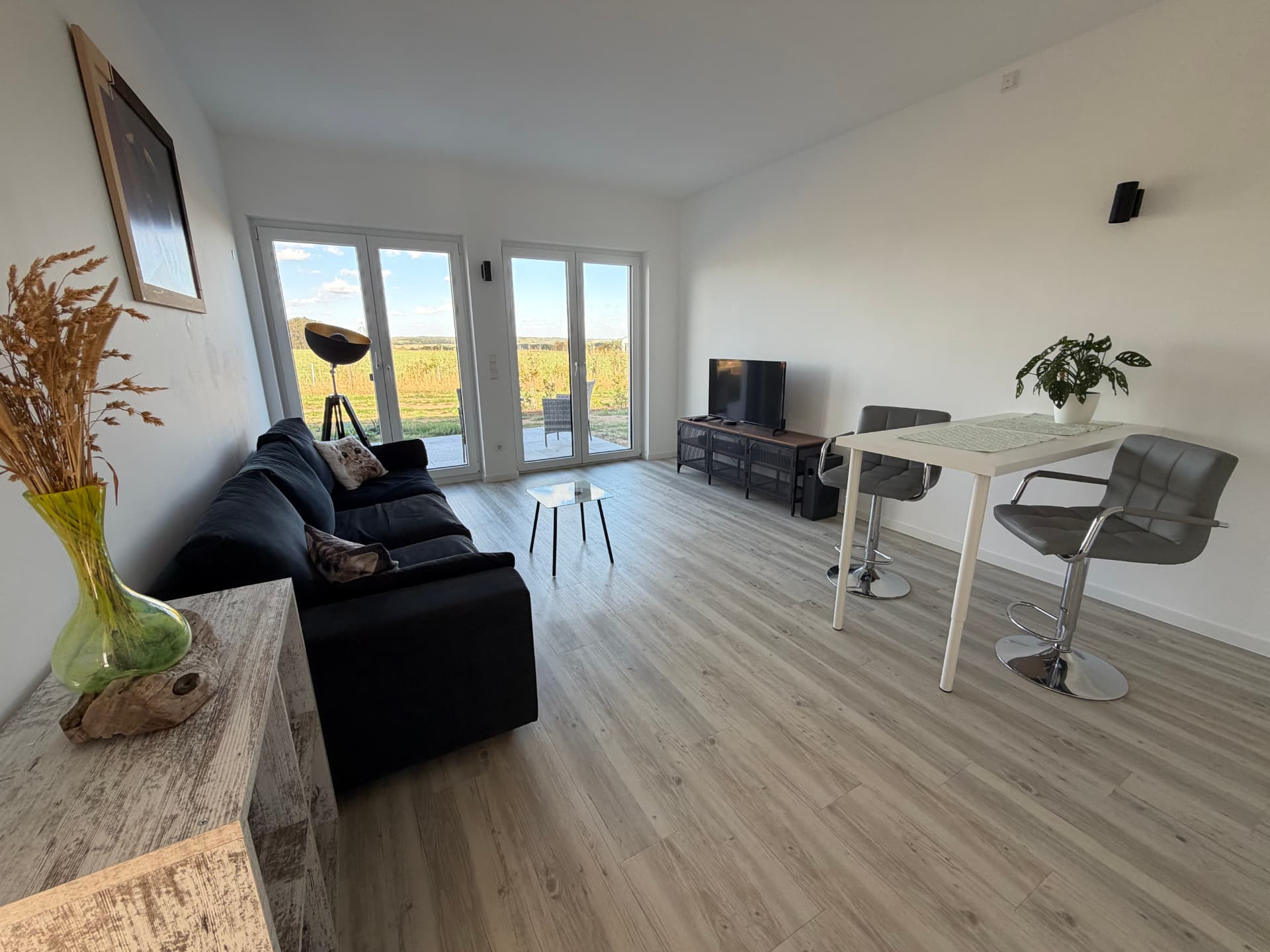 Heller Wohn- und Essbereich der Ferienwohnung mit Blick über die Felder