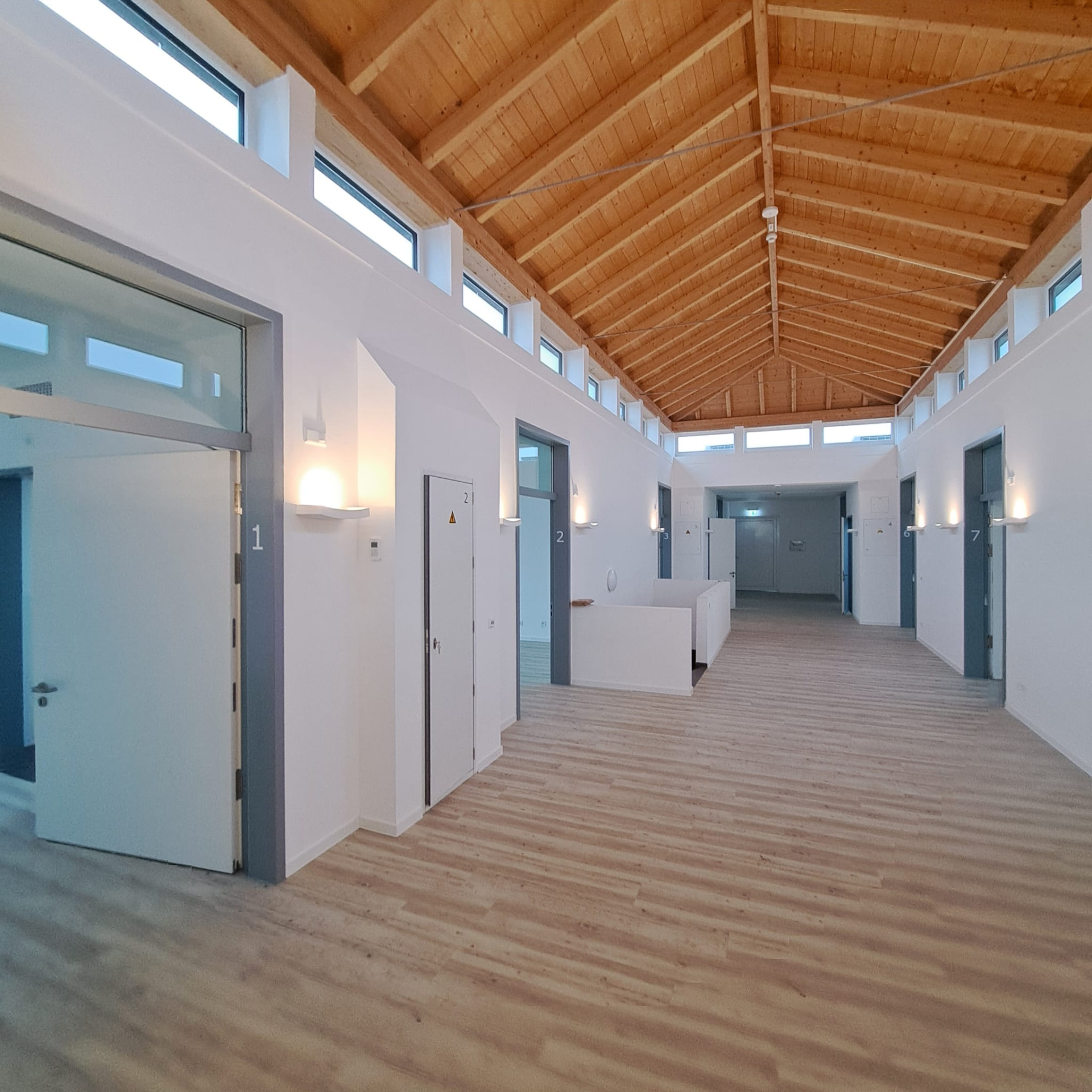 Heller Flur mit Bewohnerzimmern und Holzdecke in Haus Yvonne